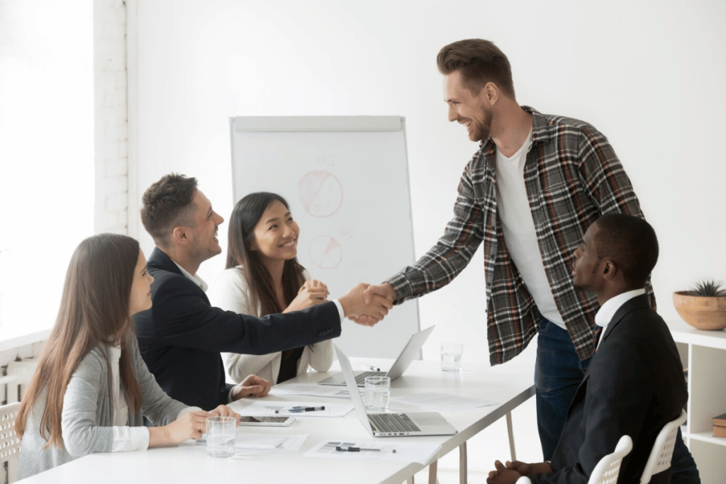 TrioSEO - A group of business people shaking hands at a meeting.