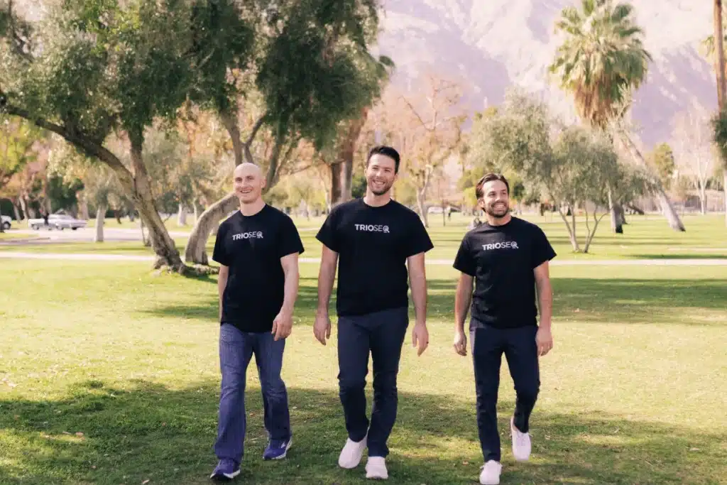 Connor, Steven and Nathan walking in a park wearing TrioSEO branded shirts.