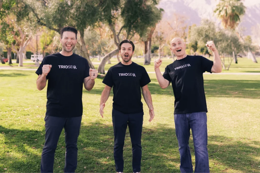 Team members of TRIOSEQ posing enthusiastically in a park.