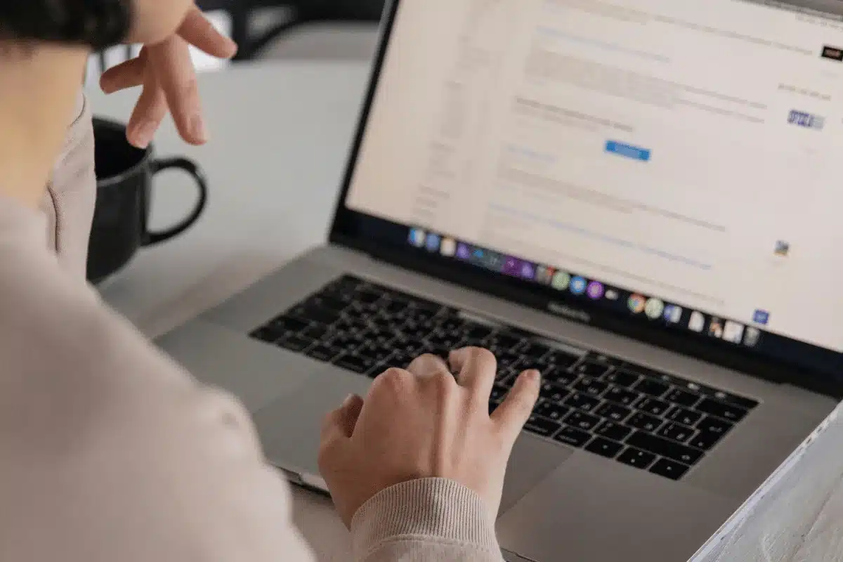 Close-up of user's hands typing on a MacBook Pro at a Wikipedia article.