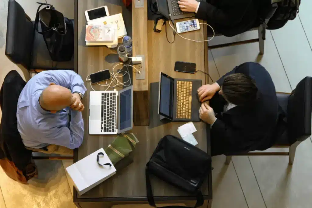 Overhead shot of a collaborative workspace featuring two people working on laptops.